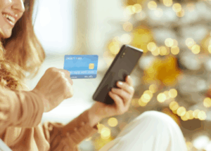 woman sitting on couch during holidays with phone and credit card